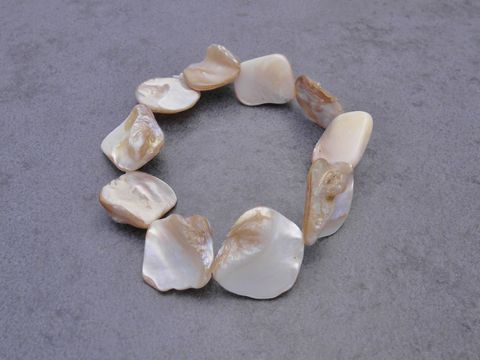 Perlmutt Armband in creme-braun mit Gummizug, 20 cm lang, hergestellt von Juwelier Harnisch, präsentiert als elegantes Perlenarmband.
