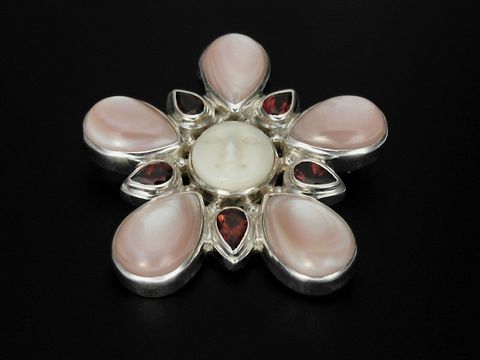 Silber Brosche und Anhänger aus rotem Perlmutt und Granat in Form einer blühenden Blüte, hergestellt von Juwelier Harnisch, mit einem faszinierenden Gesicht in der Mitte.