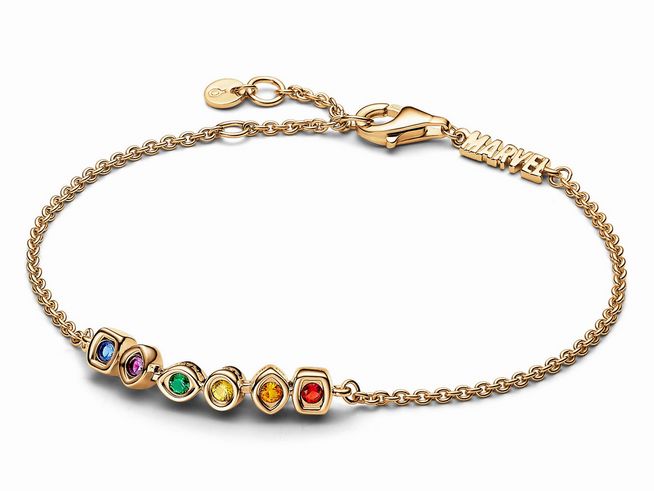 Ein elegantes Gliederarmband in Gelbgold Vergoldung mit mehreren bunten Kristallen, inspiriert von Marvel, zeigt die Infinity Steine und ein MARVEL Anhänger.