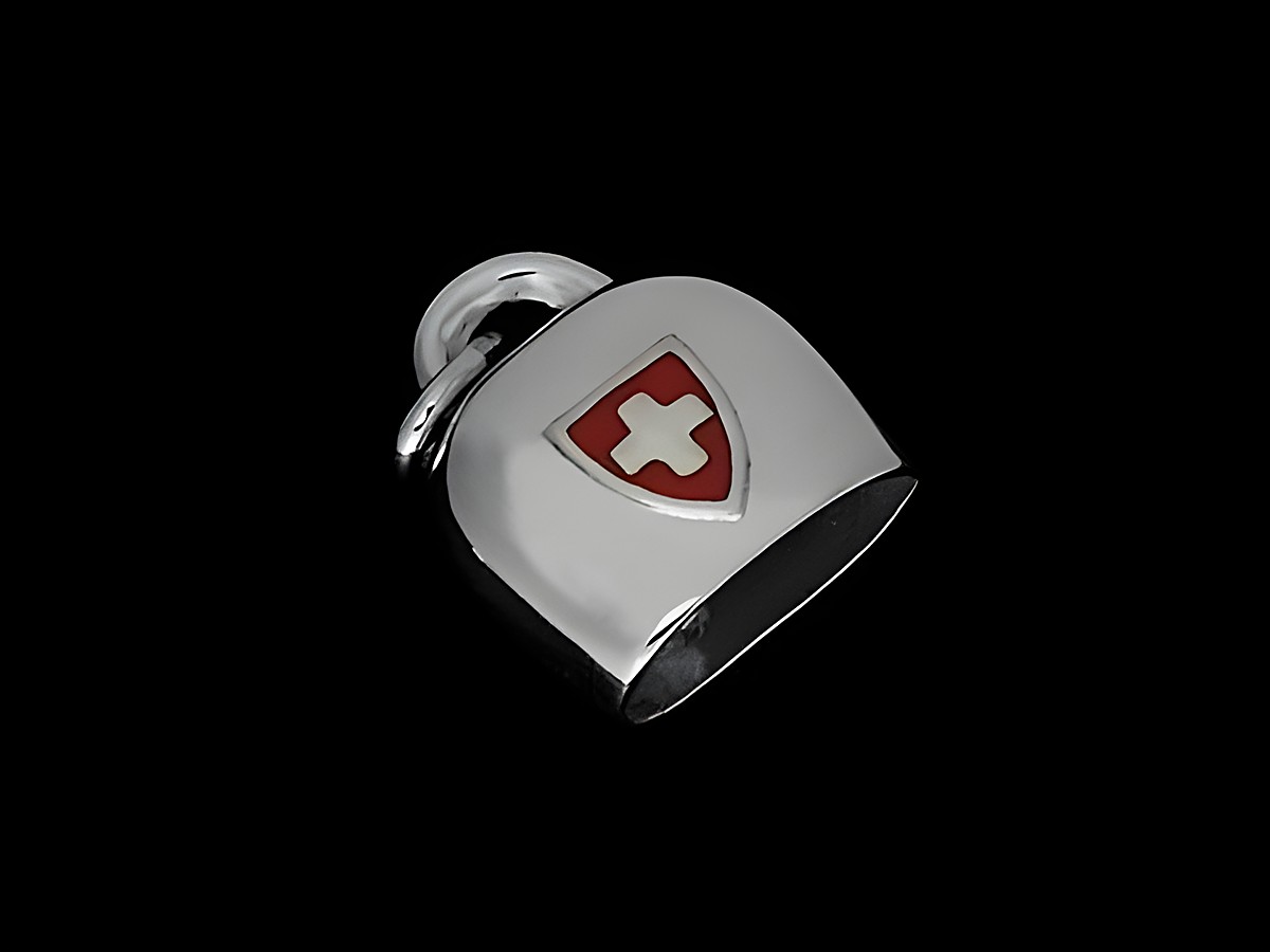 Silber rhodinierter Anhänger in Form einer Schweizer Kuhglocke mit plastischem Motiv, versehen mit dem Schweizer Kreuz auf rotem Hintergrund. Hersteller Juwelier Harnisch.