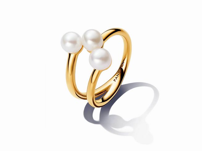 163285060-0 Süßwasserzuchtperlen offener Ring von Pandora in vergoldetem Gelbgold, getragen aus drei weißen Zuchtperlen, Größe 60, elegantes Design mit reflektierenden Oberflächen.