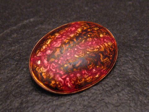 Brosche TRIBAL aus Emaille in vergoldeter Ausführung, vintage Design, hergestellt von Juwelier Harnisch, mit farbenfrohem, ornamentalen Muster in Rot- und Goldtönen.