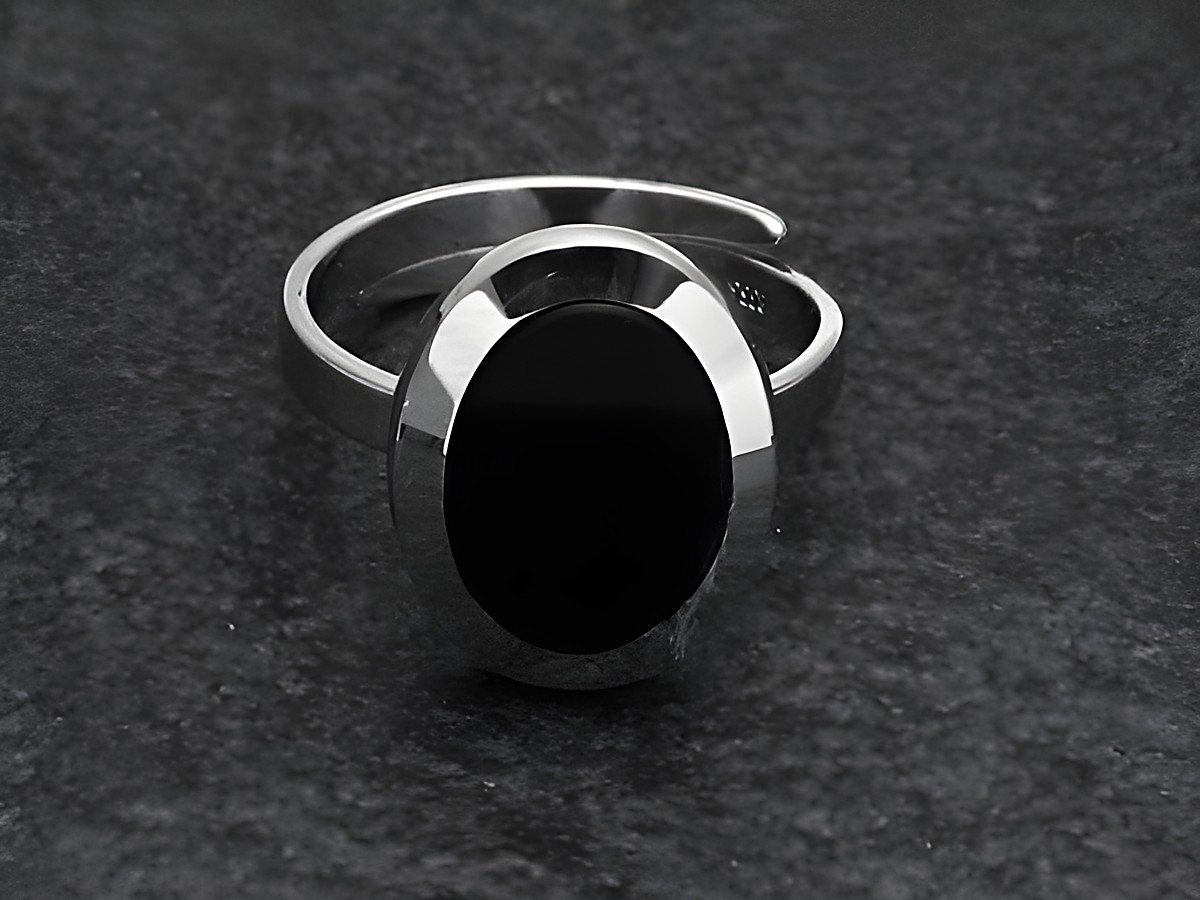 Silberring mit ovalem, verstellbarem Band und schwarzem Onyxstein, rhodiniert, hergestellt von Juwelier Harnisch, elegant und modern im Design.
