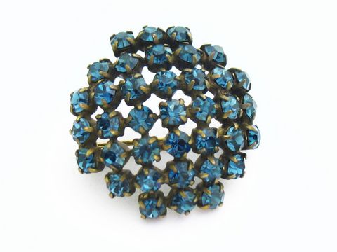 Blaue Strass Brosche im sexy City Look, rund, von Juwelier Harnisch. Funkelnde blaue Steine verleihen der Brosche einen eleganten und ansprechenden Look. Ideal für jeden Anlass.