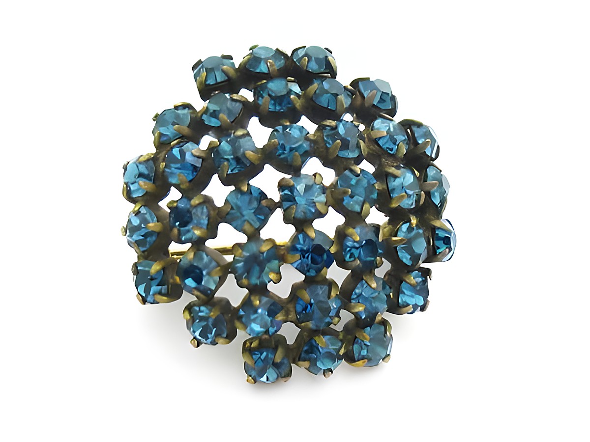 Blaue Strass Brosche im sexy City Look, rund, von Juwelier Harnisch. Funkelnde blaue Steine verleihen der Brosche einen eleganten und ansprechenden Look. Ideal für jeden Anlass.