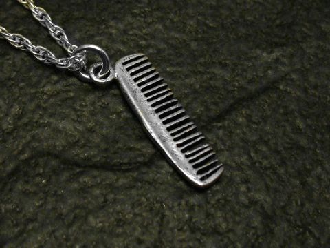 Ein feiner Kamm aus Sterling Silber als Anhänger, hergestellt von Juwelier Harnisch, ideal für Stilbewusste und Friseure als modisches Accessoire.