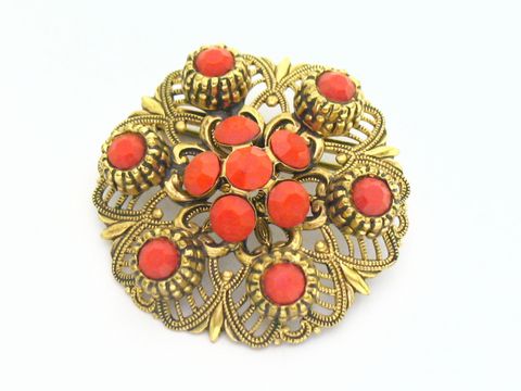 Damen Designer Brosche im Sexy City Look in Rot, rund, mit goldfarbenem Rahmen und roten Steinen, Hersteller Juwelier Harnisch, eleganter Modeschmuck für stilvolle Akzente.