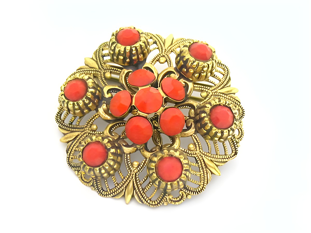 Damen Designer Brosche im Sexy City Look in Rot, rund, mit goldfarbenem Rahmen und roten Steinen, Hersteller Juwelier Harnisch, eleganter Modeschmuck für stilvolle Akzente.