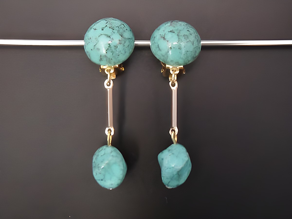 Ohrclip in zeitlosem Design mit türkisfarbenem Kunstharz und goldfarbenen Elementen, hergestellt von Juwelier Harnisch, ideal für jeden Anlass.