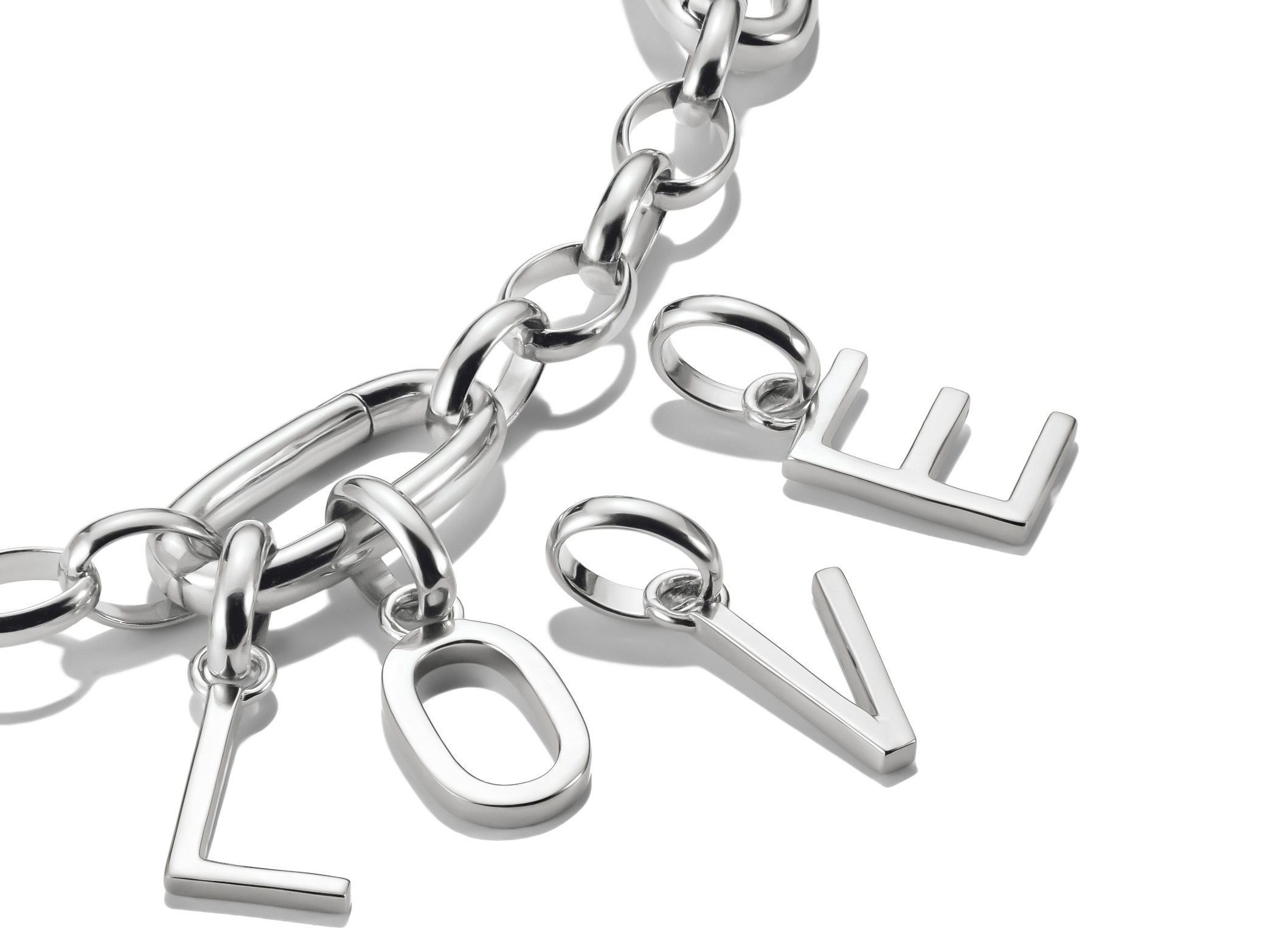 Charm mit silbernem Lettering in Form des Wortes LOVE, bestehend aus vier Buchstaben, angebracht an einer eleganten Gliederkette, stilvoll und modern.