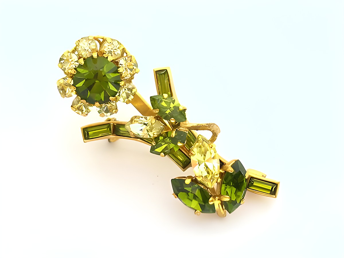 Strass Brosche in sexy Grün, gefasst mit funkelnden Kristallen, neuer Stil von Juwelier Harnisch. Elegantes Design ideal für besondere Anlässe.