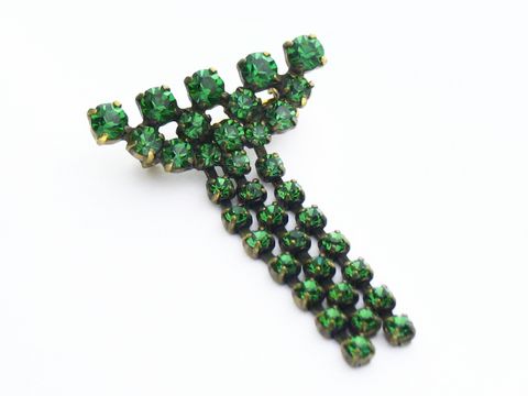 Grüne Strass Brosche in elegantem Sexy City Look von Juwelier Harnisch, besteht aus funkelnden grünen Strasssteinen in dekorativem Design. Ideal für stylische Akzente.