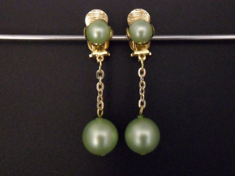 Ohrclip lemon zeitlos in goldfarben mit Kunstharz von Juwelier Harnisch, elegante Gestaltung mit hängenden, grünen Perlen und feiner Gliederkette. Ideal für besondere Anlässe.