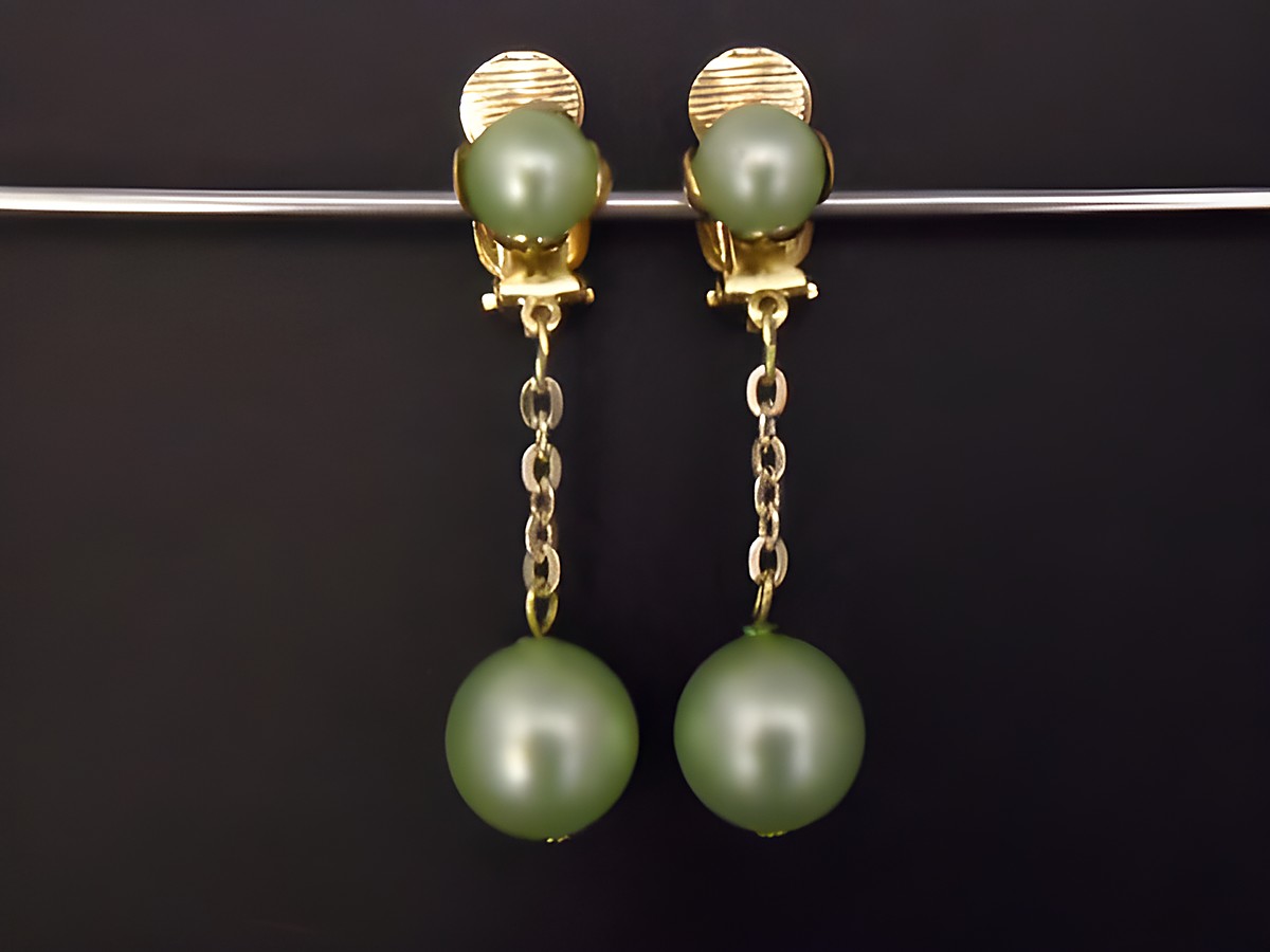 Ohrclip lemon zeitlos in goldfarben mit Kunstharz von Juwelier Harnisch, elegante Gestaltung mit hängenden, grünen Perlen und feiner Gliederkette. Ideal für besondere Anlässe.