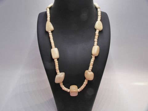 Holzkette Multiform 25 mm naturbraun 60 cm Holz Schmuck von Juwelier Harnisch, bestehend aus verschiedenen holzfarbenen Formen und unterschiedlichen Längen, elegant präsentiert auf einem schwarzen Schmuckständer.