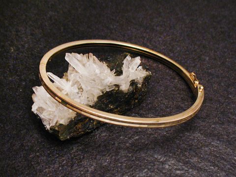 Armreifen facettenreich - 3 mm - echt Gold - 20 cm auf einem schwarzen Untergrund, elegant präsentiert auf einer Kristallbasis, Hersteller: Juwelier Harnisch, Gold Armreifen.