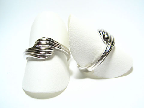Silber Ring rhodiniert aus den 70er Jahren, Größe verstellbar, Hersteller Juwelier Harnisch, ohne Stein, mit geschwungener Form und glänzender Oberfläche.