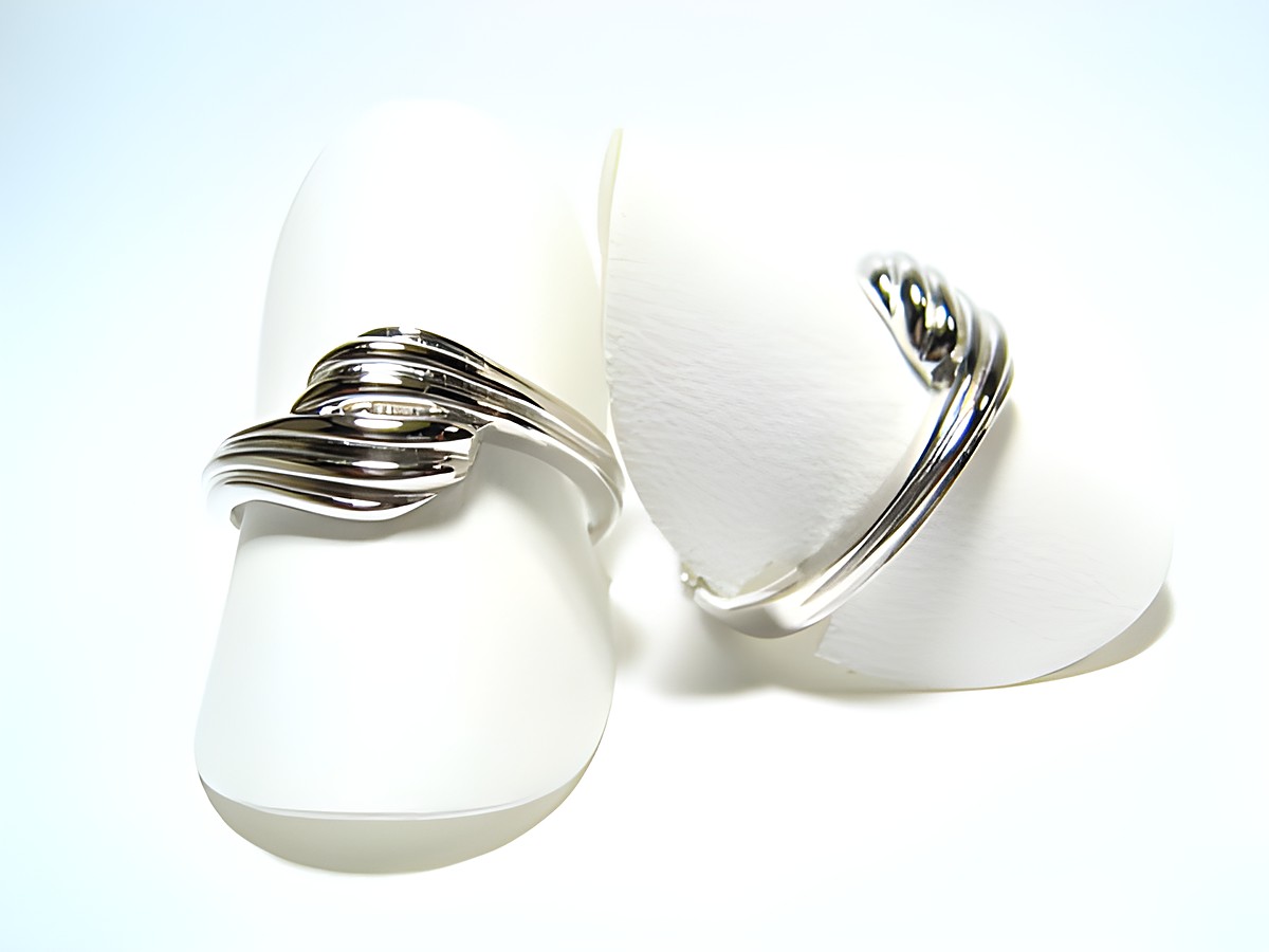 Silber Ring rhodiniert aus den 70er Jahren, Größe verstellbar, Hersteller Juwelier Harnisch, ohne Stein, mit geschwungener Form und glänzender Oberfläche.