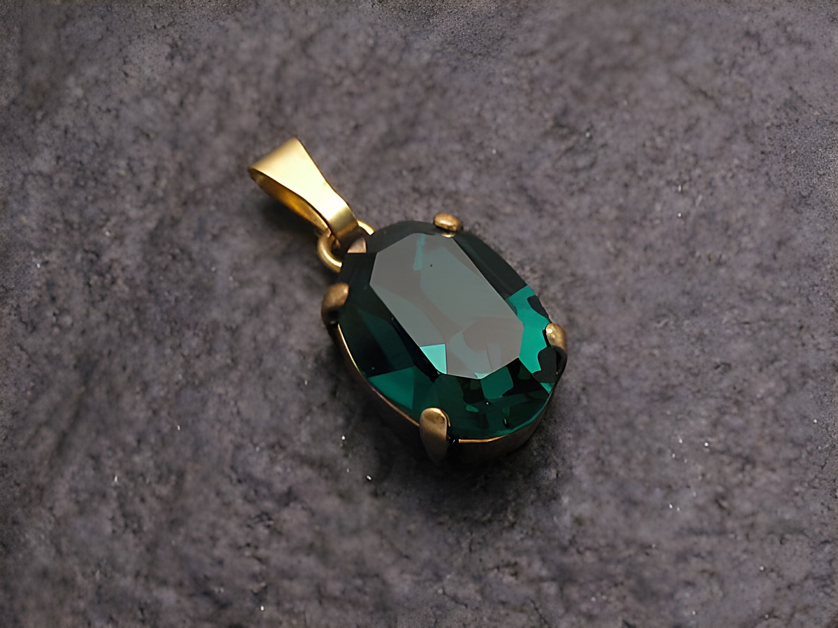 Grüner Strass Anhänger im sexy City Look in ovaler Form, gefertigt von Juwelier Harnisch, glänzender grüner Stein in goldfarbener Fassung, ideal für elegante Schmucksets.