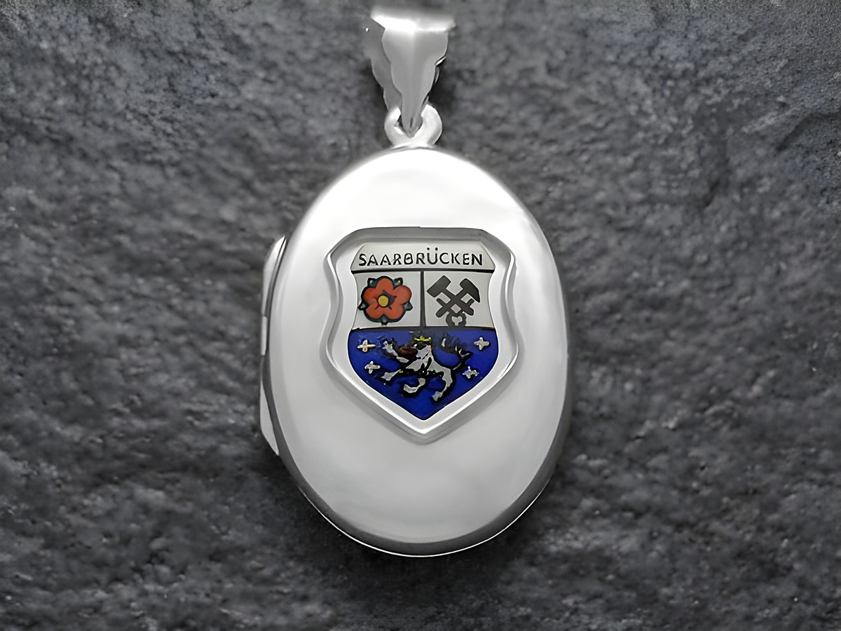 Silbernes Medaillon mit dem Stadtwappen von Saarbrücken, Deutschland. Das Wappen zeigt als zentrale Elemente eine Blume und zwei gekreuzte Schlägel, umgeben von einem blauen Schild.