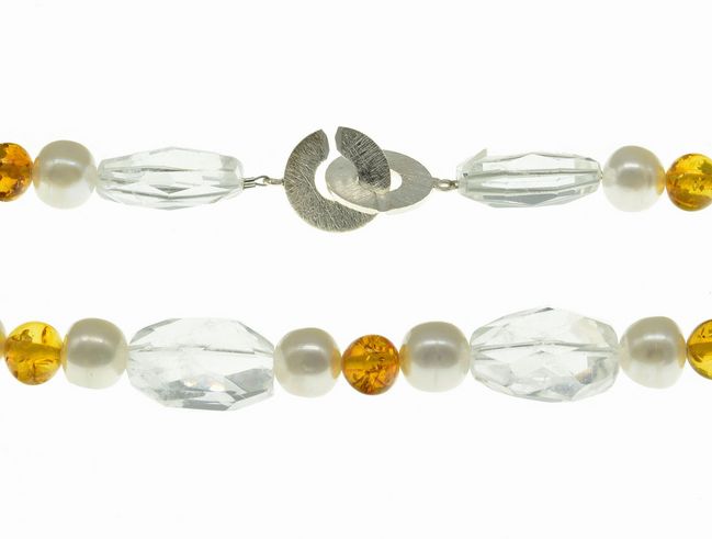 Steinkette aus Bernstein, Bergkristall und Süßwasser-Zuchtperlen in Weiß und Orange, 42 cm lang mit silbernem Verschluss. Elegantes Design für stilvolle Akzente.