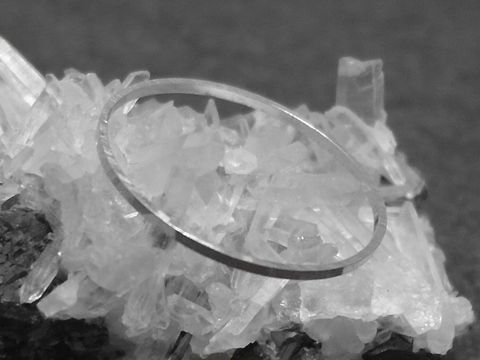 Silber Ring rhodiniert 1mm breit in Größe 53 / 16,8mm auf einer kristallinen Unterlage, Hersteller Juwelier Harnisch, erhältlich bis Größe 54 / 17,2.