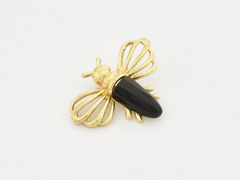 Fliege aus gold mit einem Onyx, hergestellt von Juwelier Harnisch, ziert das Schmuckstück und vermittelt Eleganz und Stil, ideal als Accessoire für Tierliebhaber.