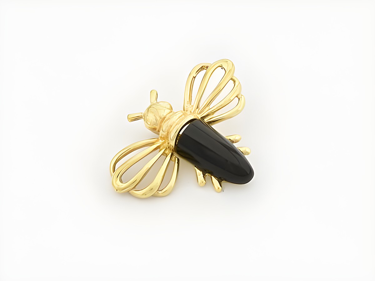 Fliege aus gold mit einem Onyx, hergestellt von Juwelier Harnisch, ziert das Schmuckstück und vermittelt Eleganz und Stil, ideal als Accessoire für Tierliebhaber.