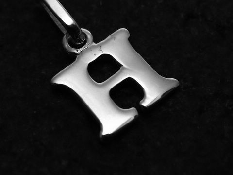 46999-0 H Buchstaben Anhänger aus 585 Weißgold, hochwertig verarbeitet und glänzend, präsentiert den Buchstaben H, ideal als persönliches Schmuckstück oder Geschenk. Hersteller Juwelier Harnisch.