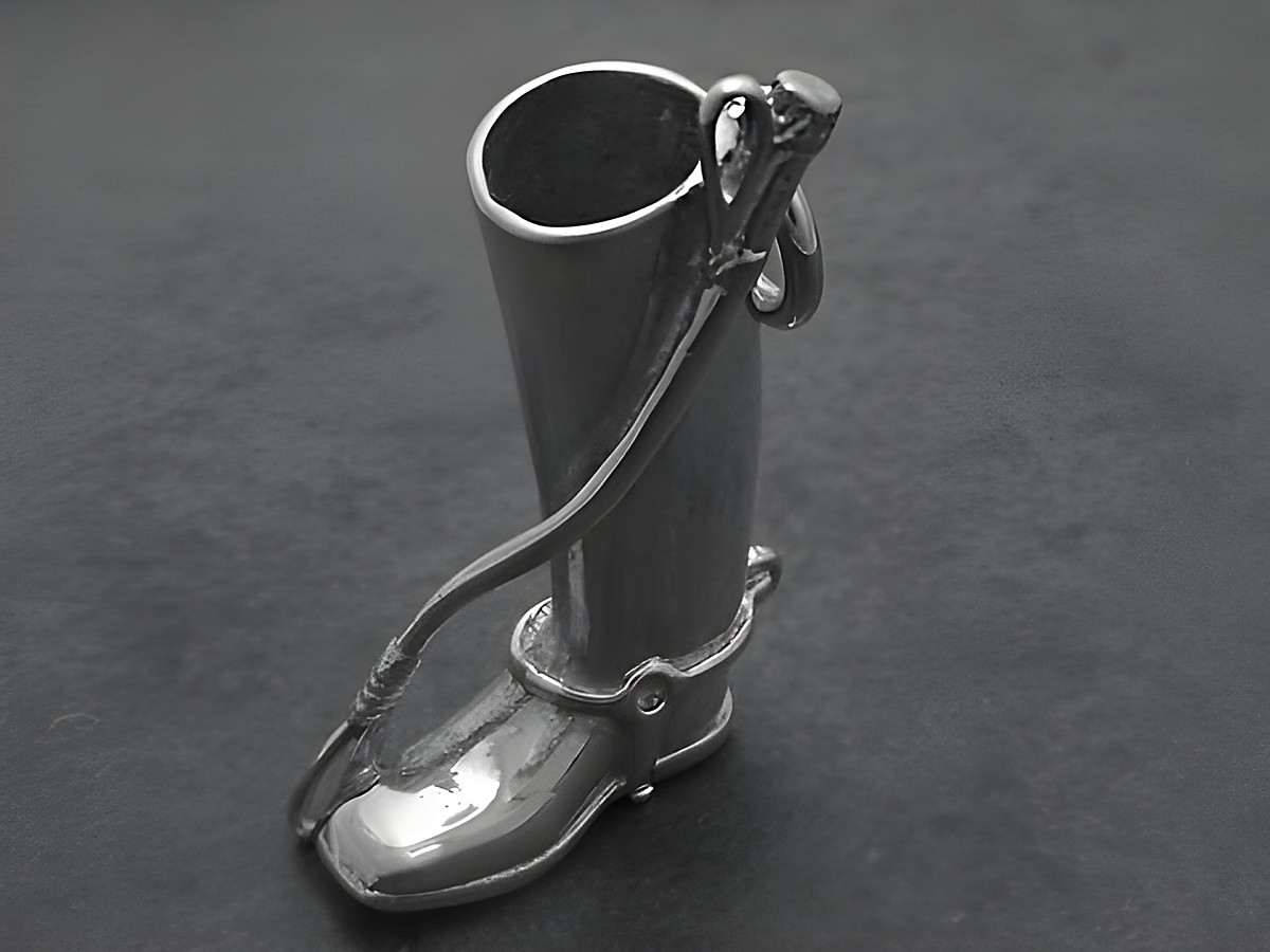 Silber Anhänger in Form eines Reitstiefels mit einer Gerte, ideal für Pferdesportliebhaber, hergestellt von Juwelier Harnisch. Schmuckdesign elegant und sportlich.