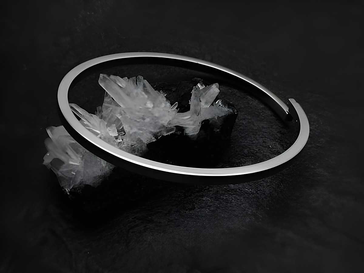Armreifen blank 3 mm echt Silber rhod 18 cm von Juwelier Harnisch, elegant und minimalistisch auf einem schwarzen Untergrund mit Kristallen inszeniert.