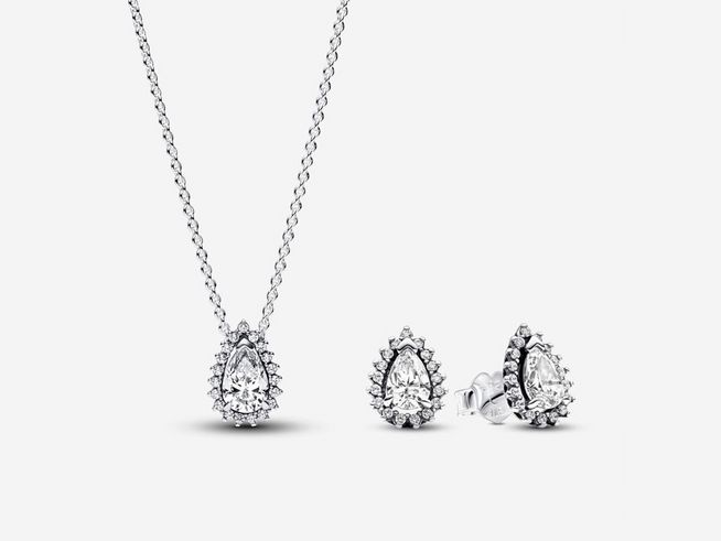 Ein elegantes Schmuckset bestehend aus einer Halskette mit tropfenförmigem Anhänger und passenden Ohrringen, beide verziert mit weißen Zirkonia und aus Sterling Silber gefertigt.