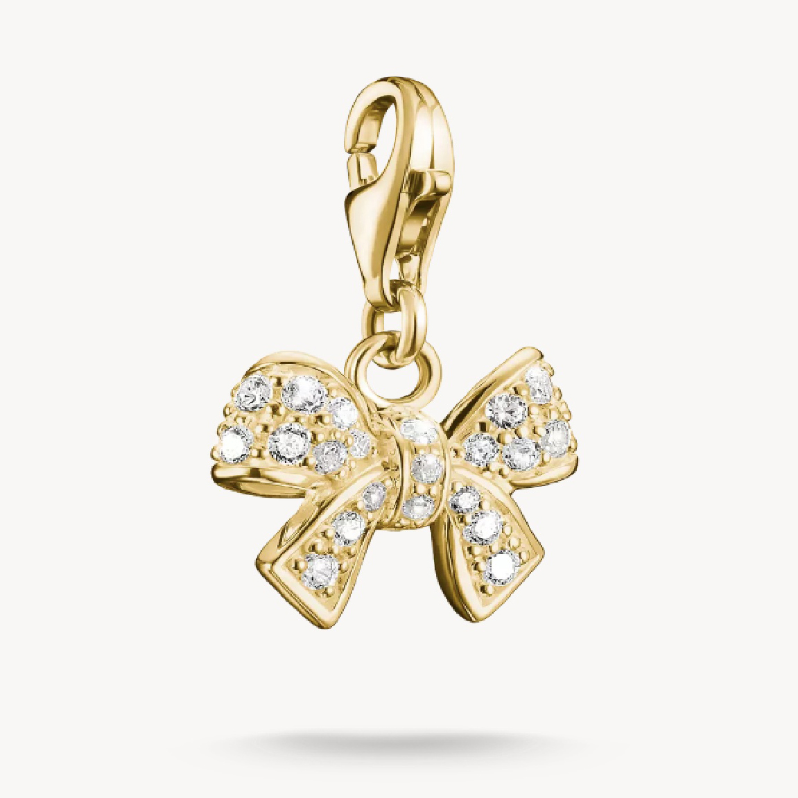 charm in Form einer Schleife aus 18k Gelbgold Vergoldung, verziert mit Zirkonia-Steinen, glänzend und elegant, ideal zum Ergänzen von Schmuckkollektionen, Hersteller Thomas Sabo, Neuheiten.