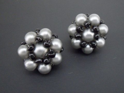Dunkelgrau-schwarzer blumiger Ohrclip mit goldfarbenen Details und synthetischen Zuchtperlen, Hersteller Juwelier Harnisch, elegant und dekorativ.