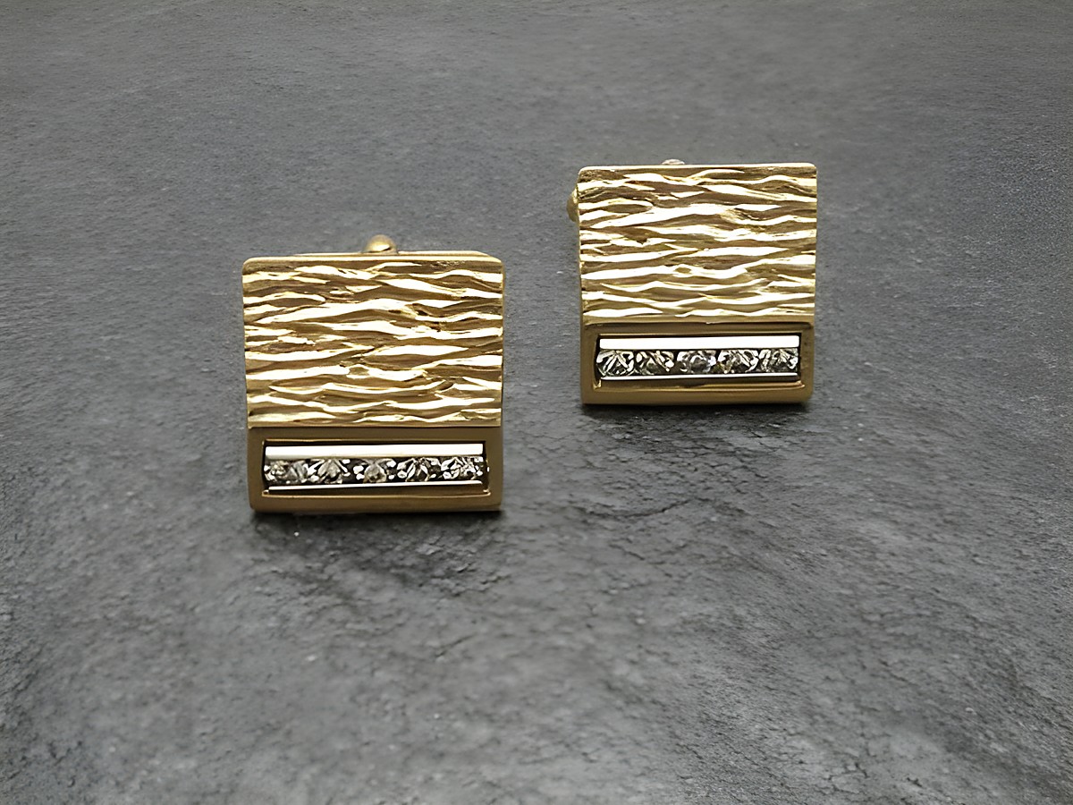Vergoldete Manschettenknöpfe mit eleganten, funkelnden Strass-Steinen von Juwelier Harnisch, goldfarben und mit strukturierter Oberfläche, ideal für stilvolle Anlässe.
