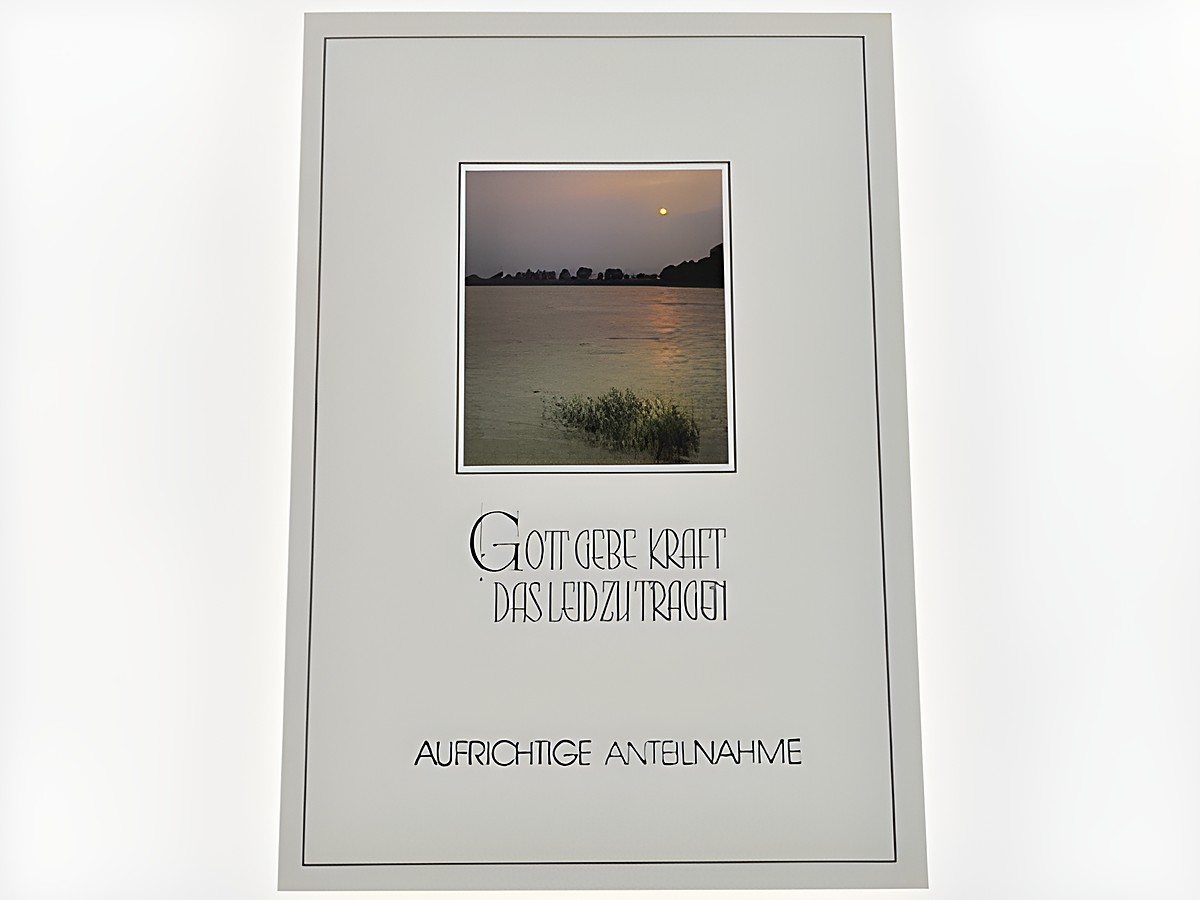 Eine Trauerkarte mit einem sanften Abendsee, der im Dämmerlicht leuchtet. Der Text "Gott gebe Kraft das Leid zu tragen" ist prominent platziert, um Trost zu spenden. Hersteller ist Juwelier Harnisch.