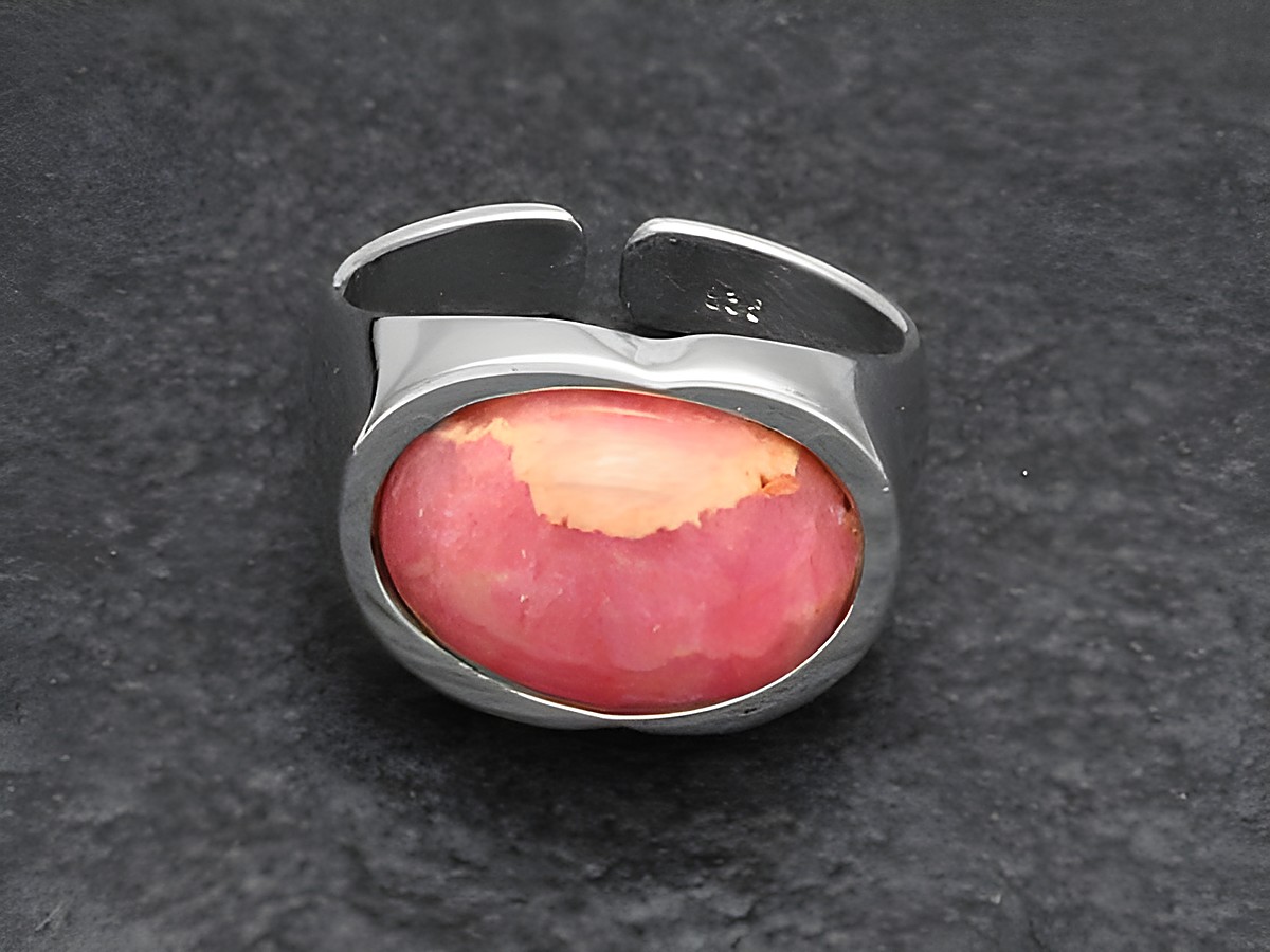 Silberring rhodiniert mit verstellbarem Design, besetzt mit einem ovalen, rosa Rhodochrosit-Stein, elegant und stilvoll, ideal für jeden Anlass. Hersteller Juwelier Harnisch.