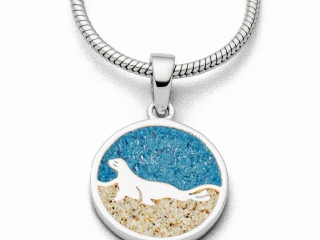 DUR Anhänger Seehund aus Sterling Silber mit einer runden Plakette, die einen stilisierten Seehund vor blauem und sandfarbenem Hintergrund zeigt.