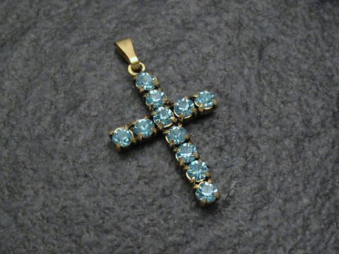 Blauer Strass Anhänger im sexy City Look in Form eines Kreuzes, hergestellt von Juwelier Harnisch, mit funkelnden blauen Strasssteinen und goldenem Anhängerohr.
