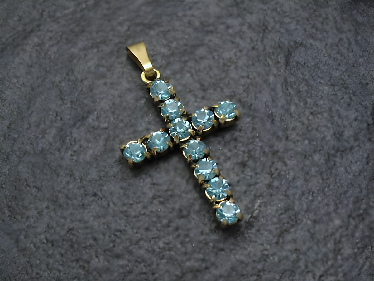 Blauer Strass Anhänger im sexy City Look in Form eines Kreuzes, hergestellt von Juwelier Harnisch, mit funkelnden blauen Strasssteinen und goldenem Anhängerohr.