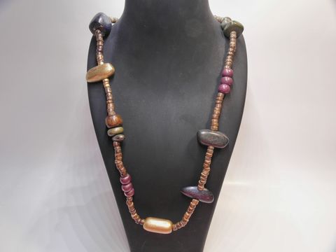 Bunte Holzkette mit einer Länge von 90 cm und einer Breite von 30 mm, gefertigt von Juwelier Harnisch, bestehend aus verschiedenen farbigen Holzperlen.