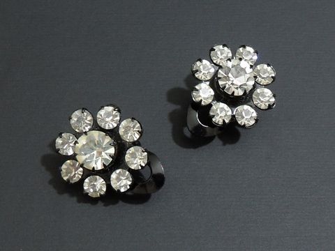 Strass Ohrclips in grazilem Design, in Weiß und Schwarz, hergestellt von Juwelier Harnisch, funkeln elegant und verleihen jedem Outfit einen Hauch von Glamour.