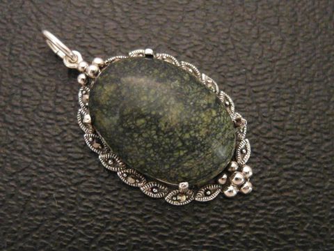 Cabochon aus russischem Serpentin in einem filigranen Silbermedaillon Anhänger, hergestellt von Juwelier Harnisch, elegante und natürliche Schmuckstückgestaltung.