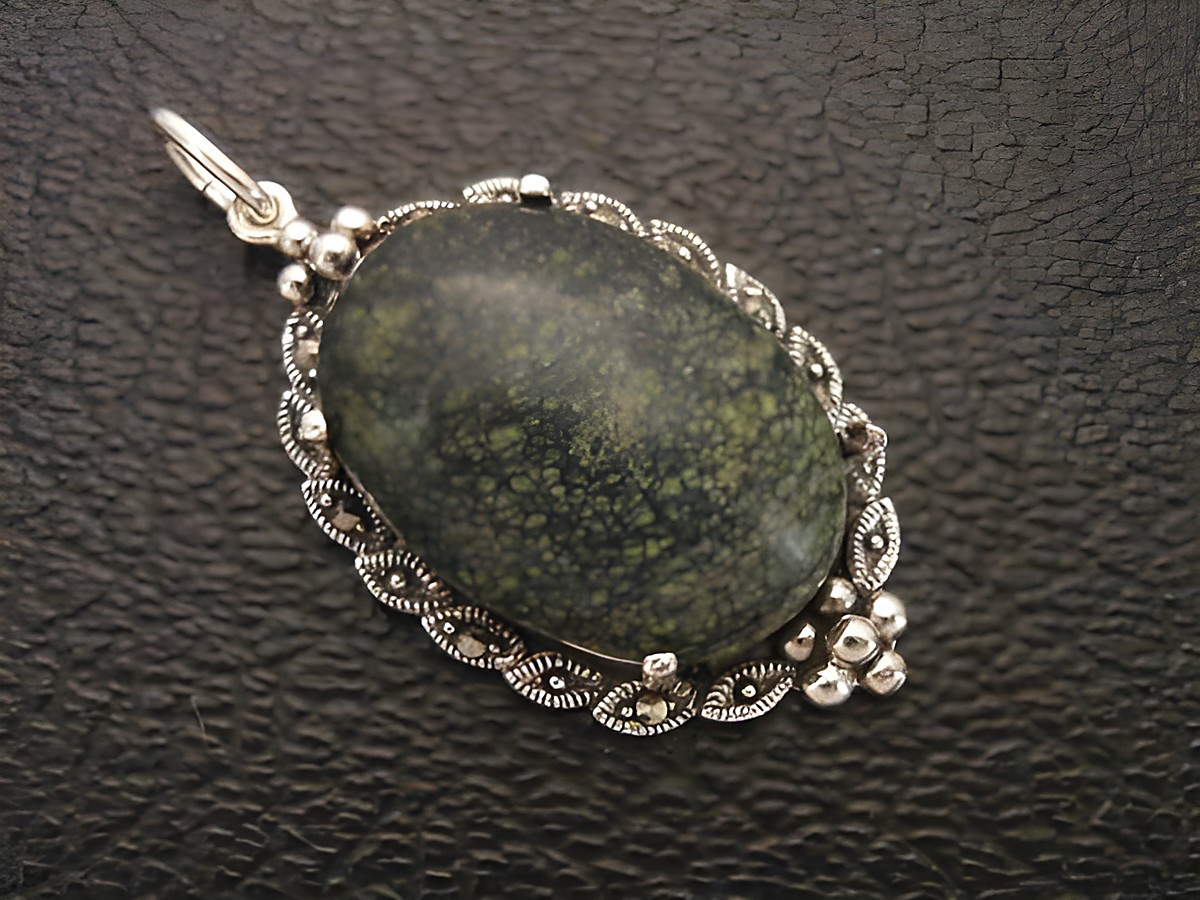 Cabochon aus russischem Serpentin in einem filigranen Silbermedaillon Anhänger, hergestellt von Juwelier Harnisch, elegante und natürliche Schmuckstückgestaltung.