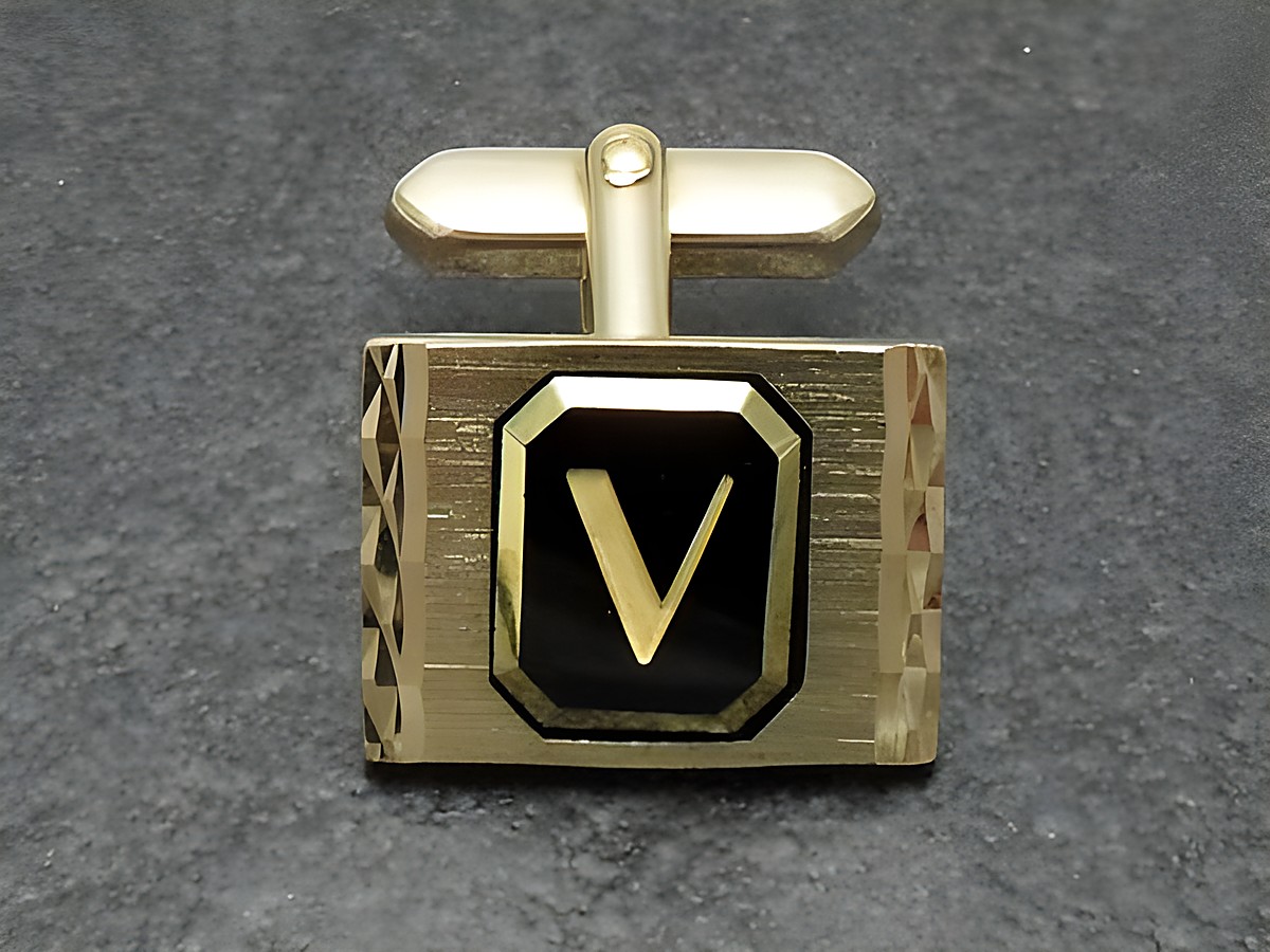 Vergoldete Manschettenknöpfe mit Initialen V, Hersteller Juwelier Harnisch, stilvolles Design mit glänzender Oberfläche und schwarzem Hintergrund, ideal für elegante Anlässe.