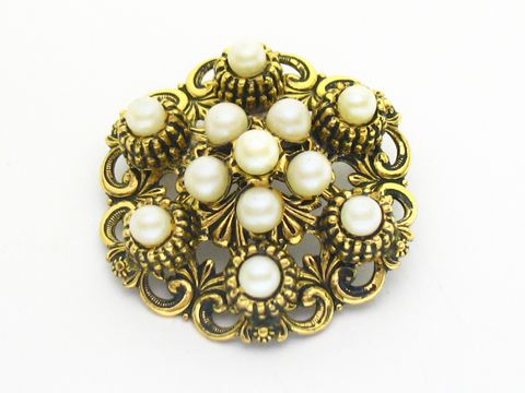 Die Brosche im Sexy City Look besteht aus goldfarbenem Metall mit Zuchtperl Imitationen, die in einer eleganten Anordnung platziert sind, idealer Modeschmuck von Juwelier Harnisch.