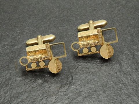 Vergoldete Manschettenknöpfe mit künstlerischem Design, Hersteller Juwelier Harnisch, goldfarben und einzigartig in Form eines Traktors, ideal für besondere Anlässe.