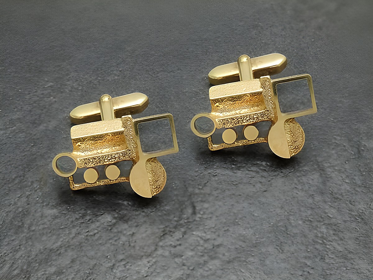 Vergoldete Manschettenknöpfe mit künstlerischem Design, Hersteller Juwelier Harnisch, goldfarben und einzigartig in Form eines Traktors, ideal für besondere Anlässe.