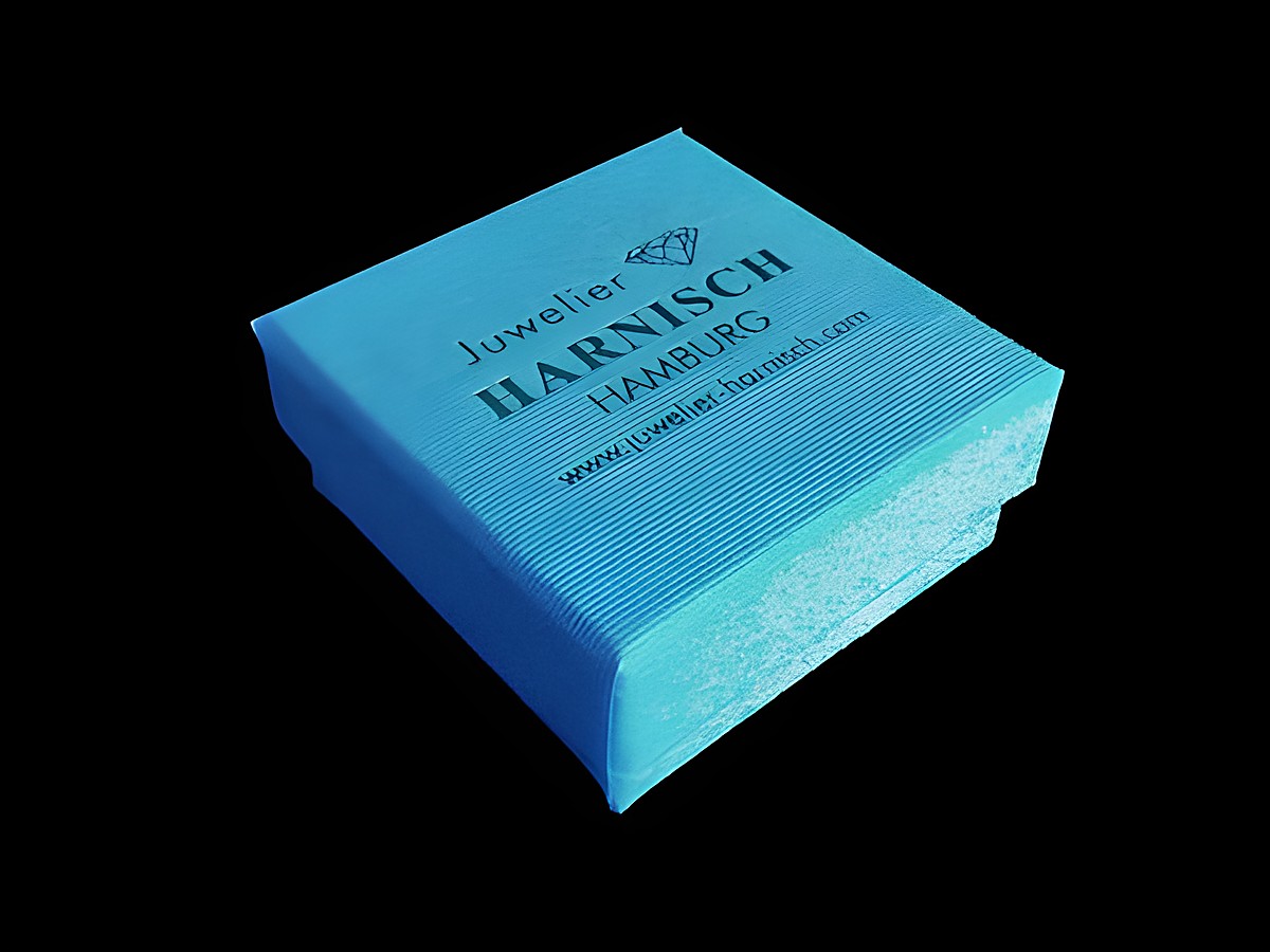 Geschenkschachtel in Blau, 4 x 4 cm, von Juwelier Harnisch. Die Geschenkbox hat eine geriffelte Oberfläche und ist mit dem Logo und der Website des Juweliers bedruckt. – Ansicht 2