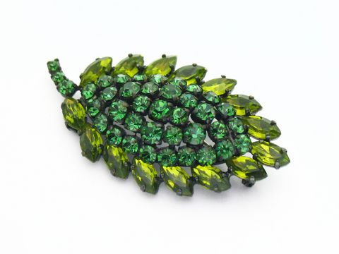 Brosche Sexy City Look Einzelstück Grün von Juwelier Harnisch mit funkelnden Strasssteinen in verschiedenen Grüntönen, die in Form eines Blattes angeordnet sind, ideal für stilvolle Akzente.